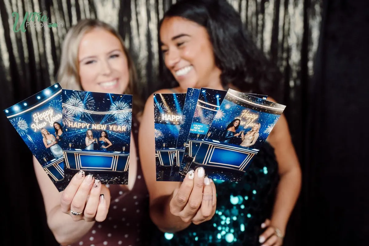 Two women holding blue game-show themed Happy New Year AI prints