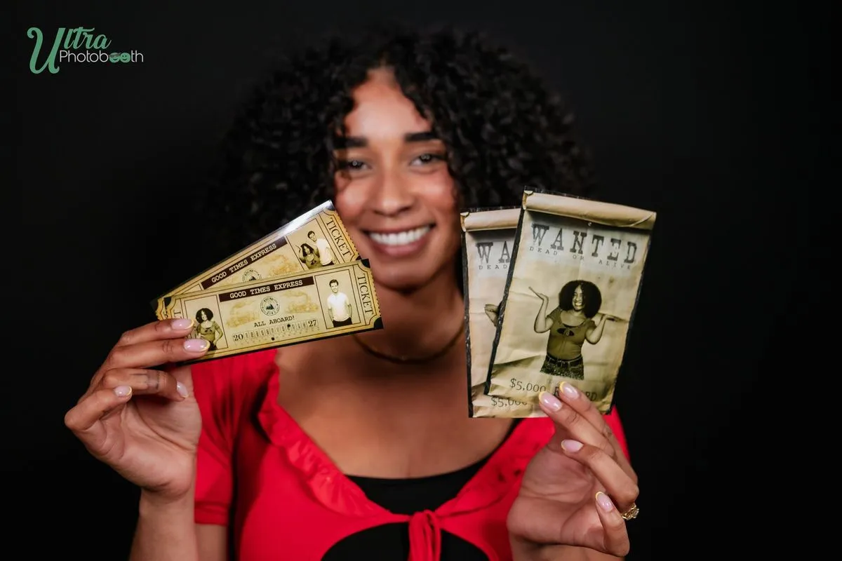 A guest holding western Wanted poster prints in front of a dark backdrop
