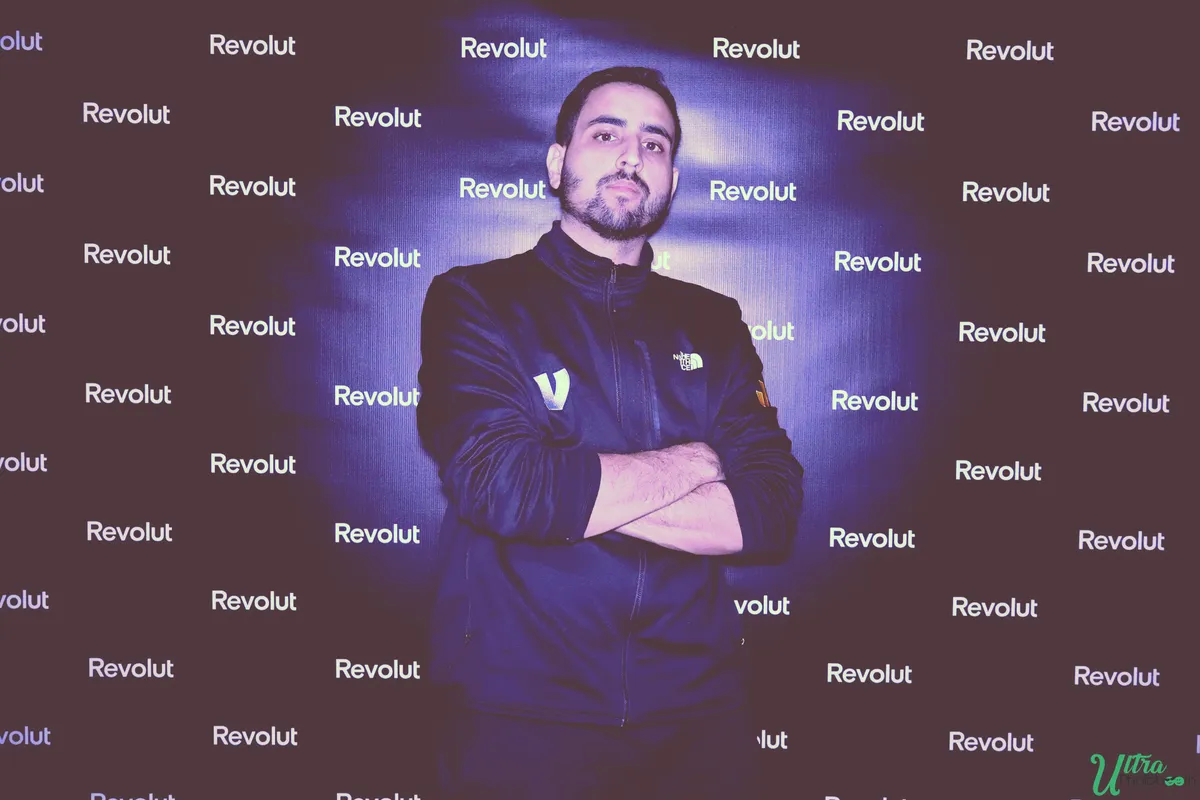 Guest posing with folded arms in front of a repeating company-logo backdrop