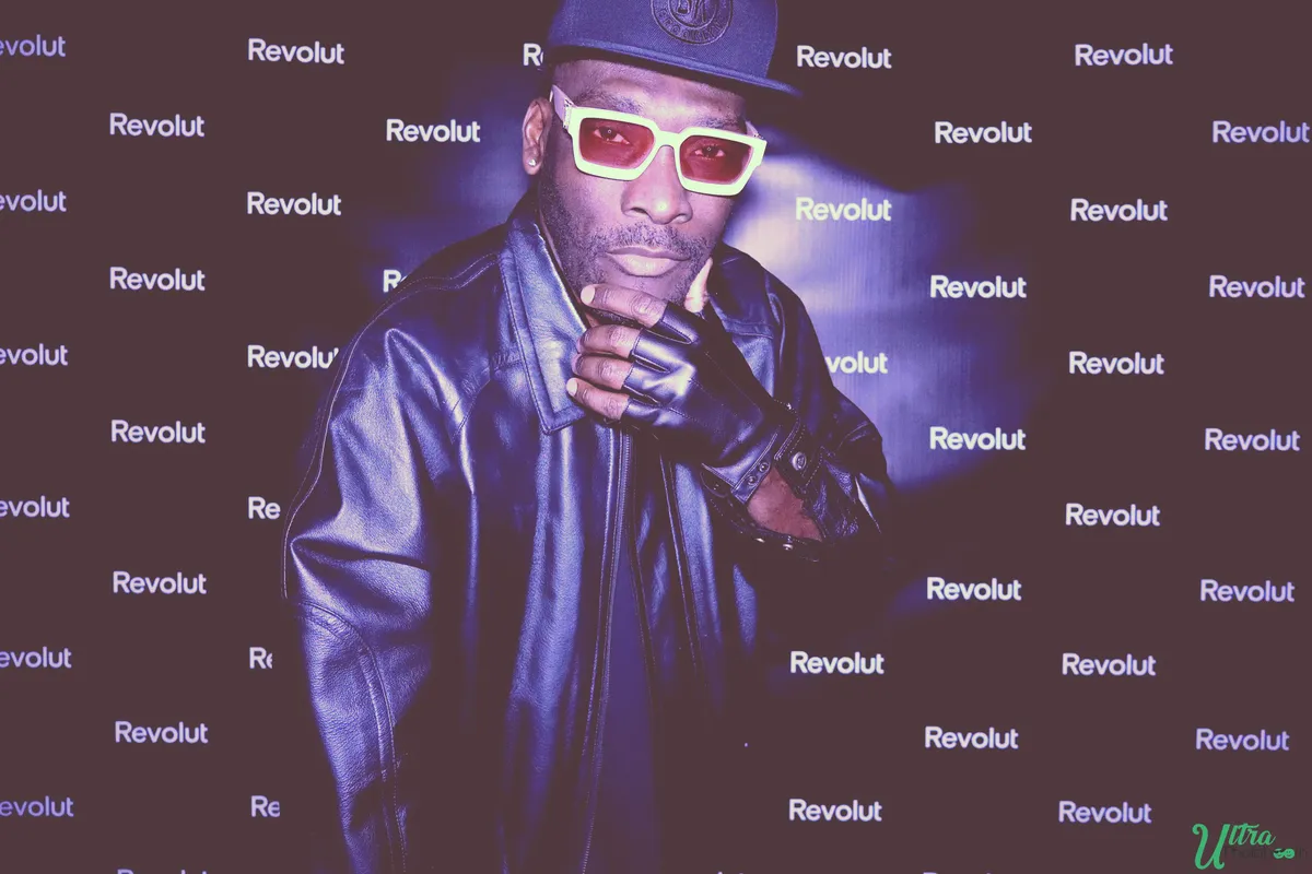 Guest wearing oversized glasses and holding a prop in front of a branded backdrop